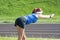 Young Red Haired Ginger Caucasian Female in Athletic Sportgear Making Arms Stretching Exercises Outdoors