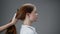 Young red-haired girl combing her hair.