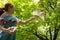 Young red haired girl with a dove in the shade of large green leafy trees