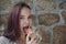 Young red-haired girl juicy licking ice cream with red tongue wi