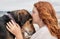 Young red haired girl kissing head of pet Huntaway dog, New Zealand