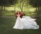 A young, red-haired princess in a crystal tiara, hugs and strokes her horse. The background is a fantastic forest glade