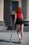 Young red-haired woman with ankle injury climbs stairs on crutches.