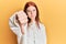 Young red head girl wearing casual sweatshirt looking unhappy and angry showing rejection and negative with thumbs down gesture