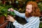 young redhaired ginger bearded man in apron working in the garden or plantation