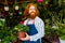 young redhaired ginger bearded man in apron working in the garden or plantation