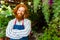 young redhaired ginger bearded man in apron working in the garden or plantation