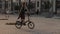 Young redhaired woman riding bicycle on street on background car moving on road