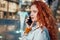 Young redhaired woman  standing at night with phone