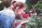 Young redhead Caucasian woman smelling rose in park
