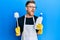 Young redhead man doing bathroom housework with toilet brush angry and mad screaming frustrated and furious, shouting with anger