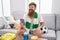 Young redhead man supporting soccer team using smartphone at home