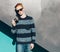 Young redhead man in a sweater and jeans standing next to green grea wall and taking photos vintage camera warm summer sunny day