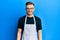 Young redhead man wearing professional apron with a happy and cool smile on face