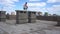 Young redhead man in a white sweatshirt sits on a brick wall on the roof