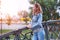 Young redhead urban woman looking at bridge at park in sunset