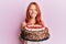 Young redhead woman celebrating birthday with cake sticking tongue out happy with funny expression