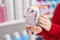 Young redhead woman client holding market kart with pills at pharmacy