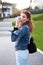 Young redhead woman drinking coffee in park and looking back in sunset