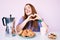 Young redhead woman eating breakfast crazy and mad shouting and yelling with aggressive expression and arms raised