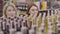 Young redhead woman with green eyes looking over shelves with alcohol as cheerful blond friend joining her. joyful adult