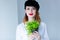 Young redhead woman in hat holding herbs of oregano