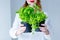 Young redhead woman in hat holding herbs of oregano and basil