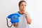 Young redhead woman holding classic retro telephone over isolated background serious face thinking about question, very confused