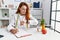 Young redhead woman nutritionist doctor at the clinic checking the time on wrist watch, relaxed and confident