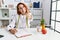 Young redhead woman nutritionist doctor at the clinic smiling friendly offering handshake as greeting and welcoming