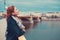 Young redhead woman smell into air and daydreaming on bridge