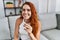 Young redhead woman smiling confident doing covid-19 test to himself at home