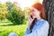 Young redhead woman talking on smartphone