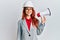 Young redhead woman wearing architect hardhat and megaphone smiling with a happy and cool smile on face
