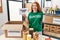 Young redhead woman wearing volunteer t shirt holding thank you banner surprised with an idea or question pointing finger with