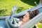 Young relaxed girl reading travel book in hammock in garden at home at bright sunny day. Slow living,