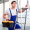 Young repairman climbing ladder at construction site