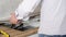 A young repairman installs a black induction hob in a modern white Scandinavian style kitchen