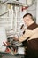 Young repairman in uniform repairing pipe in lavatory