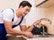 Young repairman working at the kitchen