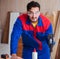 Young repairman working with a power saw sawing