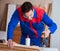 The young repairman working with a power saw sawing