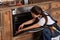 young repairwoman repairing oven