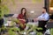 Young restful couple talking while relaxing on patio by country house