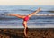 Young rhythmic gymnastics athlete trains on the beach
