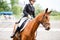 Young rider girl on horse at dressage competition