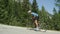 Young road biker guy charges up steep asphalt road towards the finish line.