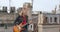 Young rock blonde girl with two funny ponytails, closed eyes , playing an electric guitar on the roof of an old building