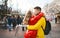 Young romantic couple in love kissing, hugging, walking on the street, wearning in bright down jackets. urban background