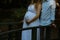 Young romantic couple of lovely future parents doing a pregnancy photoshoot in a forest